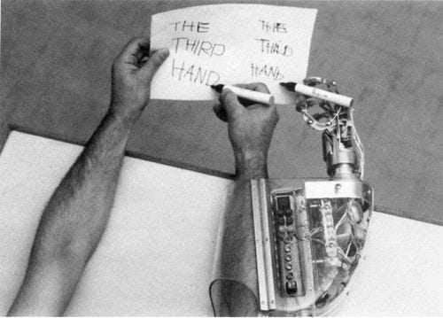 two human hands and one robot hand writing third hand on paper